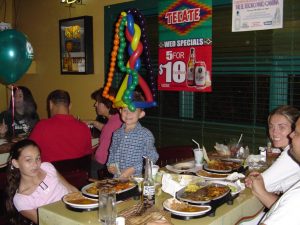 Happy kid with a balloon hat at Chevy's Miami